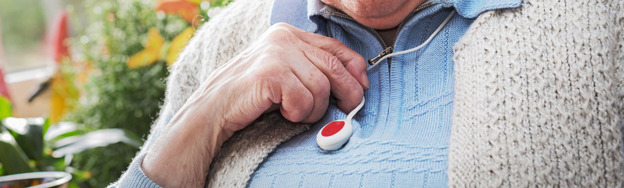 Seniorin mit ihrem Hausnotrufknopf