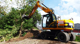 Erdbauarbeiten in mit Bäumen bewachsenen Gelände