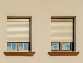 Holzrolladen Berlin vor zwei Fenstern